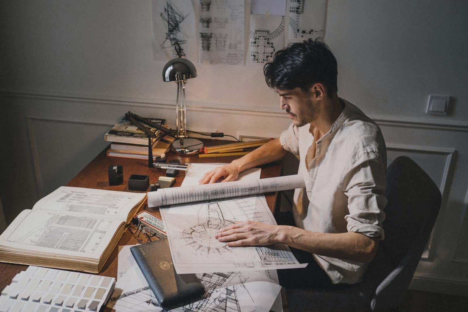 Architect working on blueprints at a drawing desk